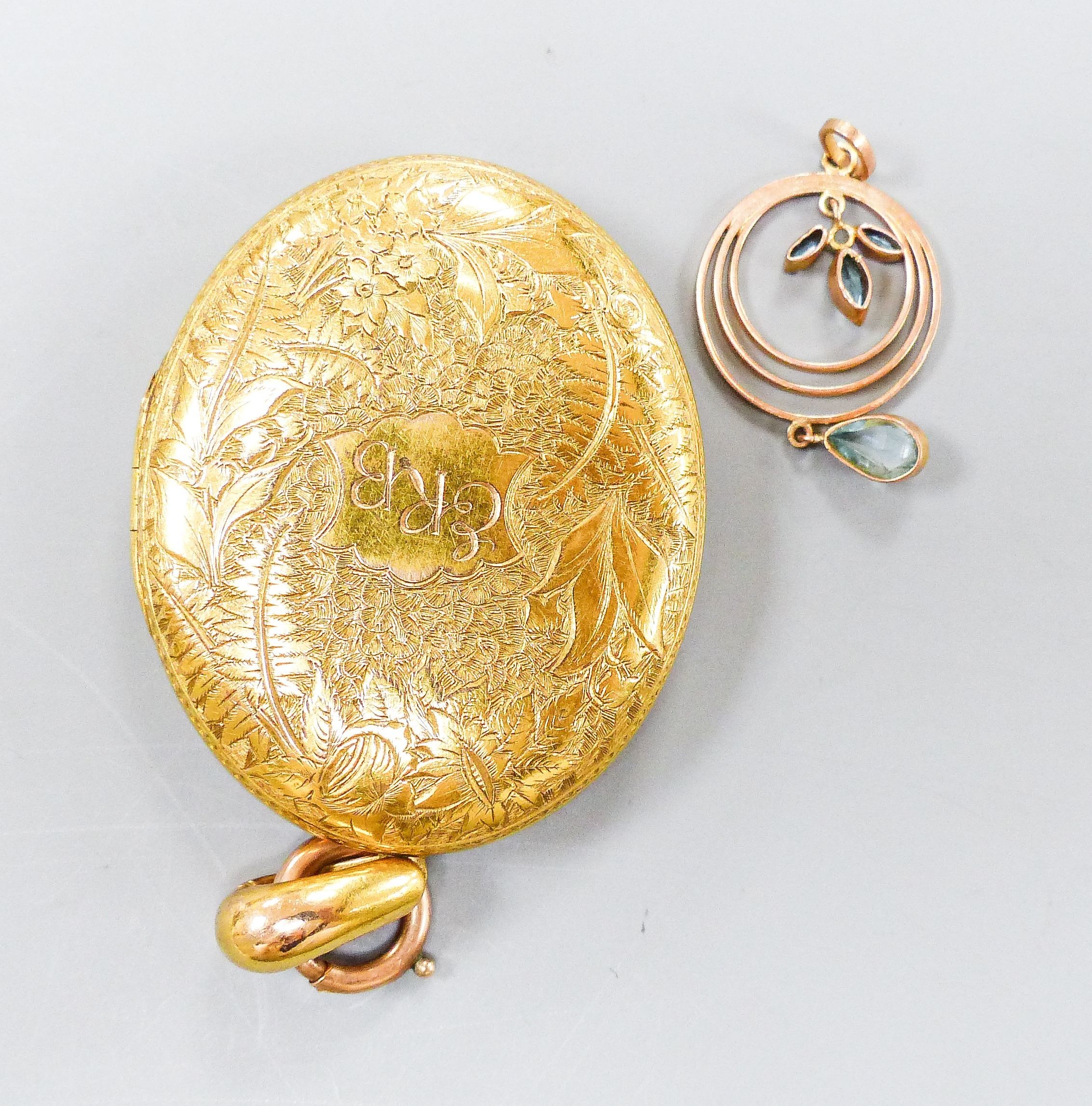 A Victorian engraved yellow metal oval locket, with engraved initials, 47mm, gross 31.6 grams, together with a small yellow metal and gem set pendant, 28mm, gross 1.5 grams.